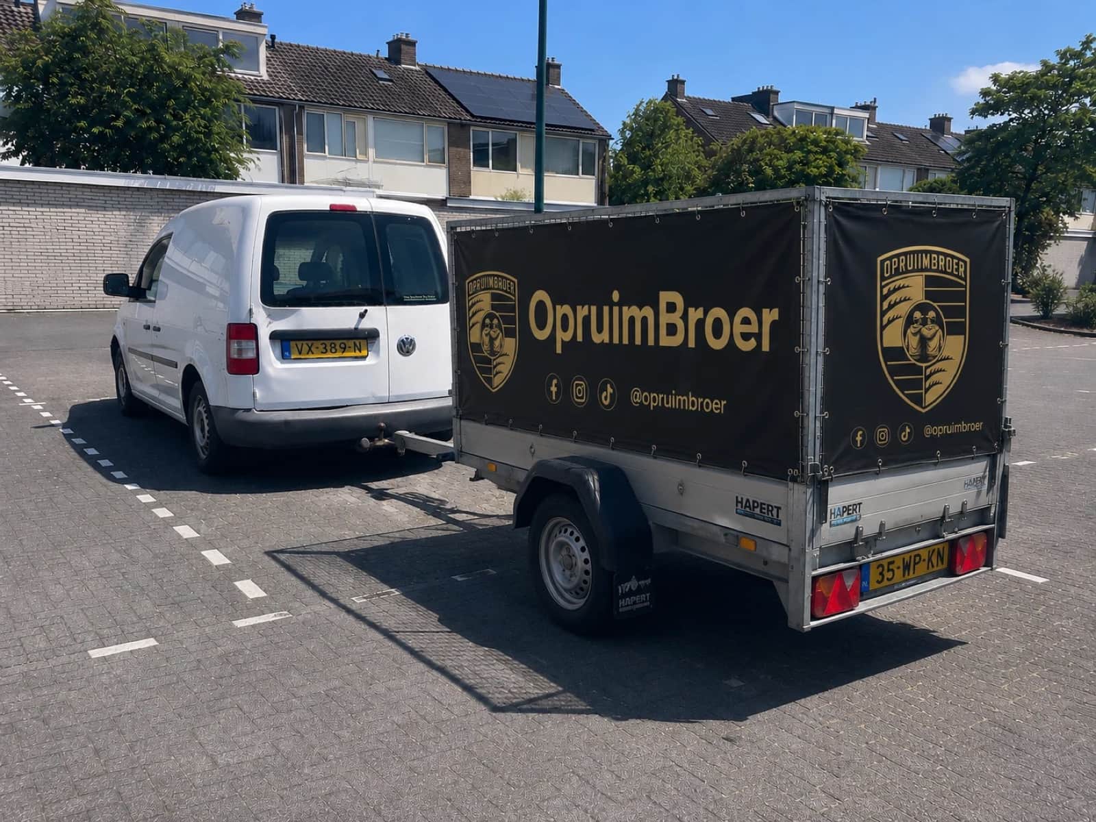 De werkbus en branded aanhanger van Opruimbroer, klaar om spullen op te halen
